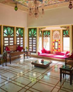 a large living room with pink furniture and windows at Mahendra Prakash in Udaipur