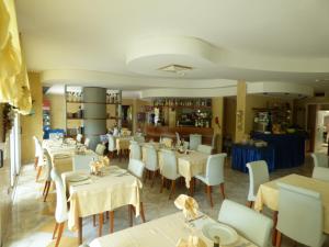 a dining room with tables and white chairs and a restaurant at Hotel Poker in Misano Adriatico +37 photos