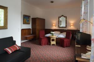 ハンブルクにあるホテル シュミットのベッドとリビングルームが備わるホテルルームです。