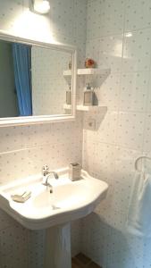 La salle de bains est pourvue d'un lavabo blanc et d'un miroir. dans l'établissement B&B La Boissière Et Le Vialat, à Montagnac