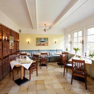 a restaurant with tables and chairs and a couch at Hotel Hof Tütsberg in Behringen