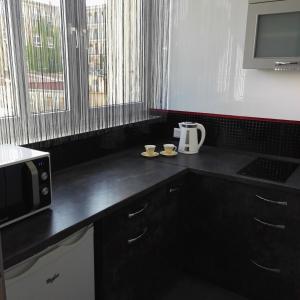 a kitchen with a black counter top with a microwave at Apartament Centrum Arma Plac Rodła in Szczecin