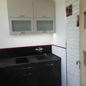 La salle de bains est pourvue d'un lavabo noir et de deux miroirs. dans l'établissement Apartament Centrum Arma Plac Rodła, à Szczecin