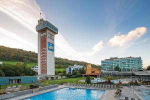 um hotel com piscina e torre em VitalBoutique Hotel Zurzacherhof em Bad Zurzach