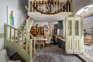 a kitchen and dining room with a staircase and a chandelier at Siliguri Traditional House in Rhodes Town