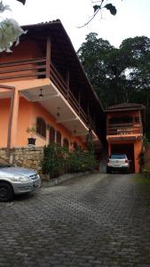 a house with a car parked in front of it at Hospedaria - Hostel Gamboa in Angra dos Reis