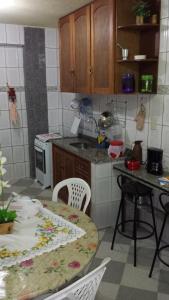 a kitchen with a table and chairs and a table and a counter at Hospedaria - Hostel Gamboa in Angra dos Reis