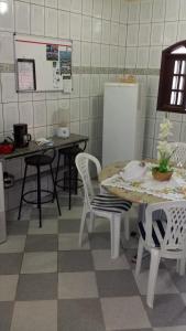 a kitchen with a table and chairs and a refrigerator at Hospedaria - Hostel Gamboa in Angra dos Reis
