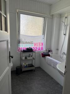 un bagno con vasca, lavandino e finestra di Brittas Bio-Bed & Breakfast a Colonia