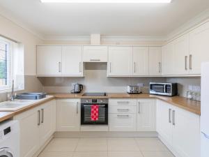 a white kitchen with white cabinets and appliances at Dawson Park 9 - Uk12668 in Mablethorpe +15 photos