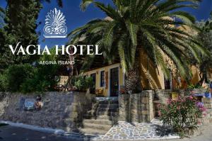 a hotel with a palm tree in front of a building at Vagia Traditional, Aegina Island in Vaia