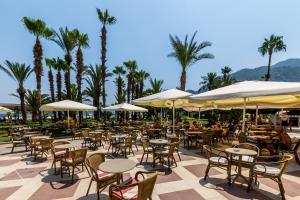 an outdoor patio with tables and chairs and umbrellas at Hotel Aqua in Marmaris