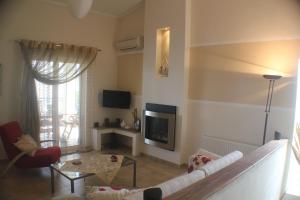 a living room with a couch and a tv at KMD House in Iraklitsa