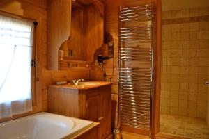 y baño con bañera y lavamanos. en Chalet le Lagopède en La Joue du Loup