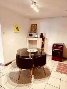 Una cocina con una mesa de cristal y sillas en una habitación. en Ti Caz de Ness, en Saint-Leu