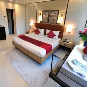 ニューデリーにあるAIRPORT HOTEL Almati EN With Free Airport Pickup Delhi Airportのベッドルーム1室(大型ベッド1台、赤い枕付)