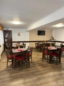 a dining room with tables and chairs and a flat screen tv at Cabana Rares in Ranca