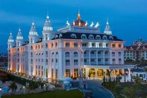 a large white building with domes on top of it at Side Royal Palace in Side