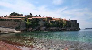 a building on an island in a body of water at Apartments Antonela in Sveti Stefan