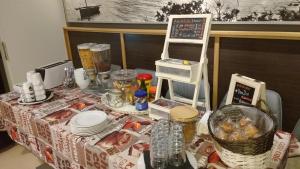 d'une table avec un chiffon de table avec de la nourriture et de la vaisselle dans l'établissement Hostal Santa Clara, à L'Estartit