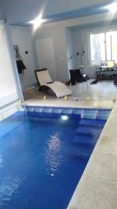 una piscina con agua azul en una habitación en Pelicano Carilo en Cariló