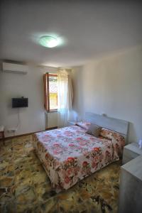 a bedroom with a bed with a floral bedspread at Da Gina in San Gimignano