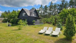 a group of chairs sitting in front of a black house at Green Hills Villa in Sakhnovka