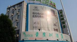 a building with a large sign on the side of it at Vatica Hengshui Halixun Peace Hospital Hotel in Hengshui