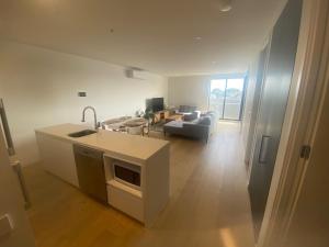 a kitchen and living room with a sink and a couch at Modern Apartment Airport Area in Melbourne