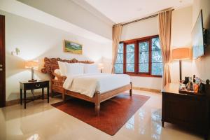 a bedroom with a bed and a window at Bumi Kinar Heritage in Ubud +81 photos