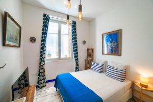 Un dormitorio con una cama con almohadas azules y blancas. en Studio Travel 22M2, 120m Vieux-Port ,Clim , Wifi ,Accès autonome avec code, en Marsella