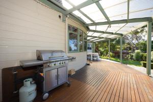 an outdoor kitchen with a grill on a wooden deck at The Avenue in Anglesea