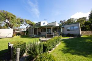 a small white house with a yard with grass at The Avenue in Anglesea