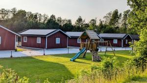 a playground with a slide in a yard with houses at Gammal björn in Dalskog