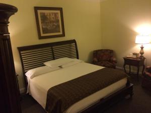 a bedroom with a large bed and a chair at The City Hotel Bar & Grill in Northern Cambria
