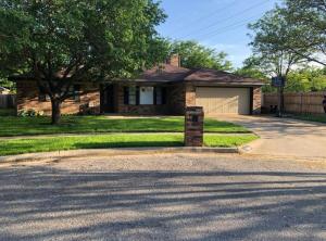 Una casa de ladrillo con un árbol y una entrada para coches. en Cozy Cul de sac 4 bed 2 bath, en Amarillo