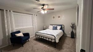 1 dormitorio con 1 cama, ventilador de techo y silla en Cozy Cul de sac 4 bed 2 bath, en Amarillo
