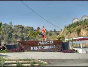 a man standing on top of a sign at Triangle Anugrah in Tegalharendong +4 photos