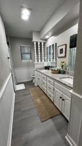 Un baño con dos lavabos y un inodoro. en Cozy Cul de sac 4 bed 2 bath, en Amarillo