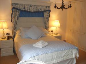 a bedroom with a bed with two towels on it at Moss Lodge in Rochdale
