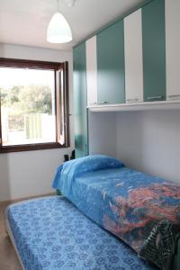 カストロ・ディ・レッチェにあるAppartamenti La Perla Del Salentoのベッドルーム(青いベッド1台、窓付)