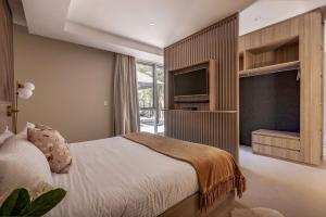 una camera da letto con un letto e una TV a schermo piatto di Sundance Estate - Summer Luxury a Yallingup