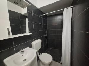 a bathroom with a white toilet and a sink at Konjic Stay in Konjic