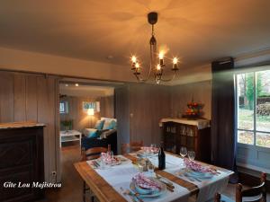 a dining room with a table and a chandelier at Hotel Logis - Chateau de Beauregard in Saint-Girons