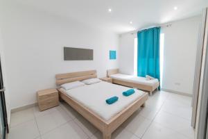 a bedroom with two beds in a room at Tonis City Apartments in St Julian's