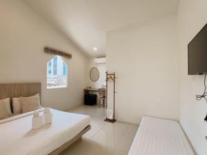 a white bedroom with a bed and a desk at LAIWAII HOME in Hat Yai