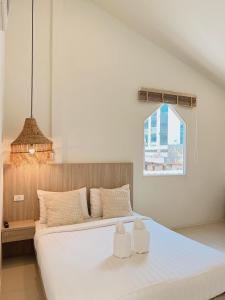 a bedroom with a large white bed with two towels at LAIWAII HOME in Hat Yai