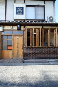 a building with wooden doors and a sign on it at 一棟貸し宿 ローカルプライド大和高田 in Yamatotakada