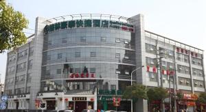 een groot gebouw met een bord erop bij GreenTree Inn Nanjing Dachang Getang Metro Station Express Hotel in Dachang