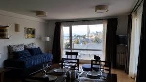 un salon avec une table et un canapé bleu dans l'établissement Centro Cívico departamentos, à San Carlos de Bariloche 13 autres photos